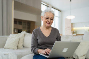 Schwerbehinderung verstehen: Warum verlässliche Gesundheitsinformationen für Betroffene und Angehörige wichtig sind Seniorin nutzt Laptop für digitale Informationen und Dokumente